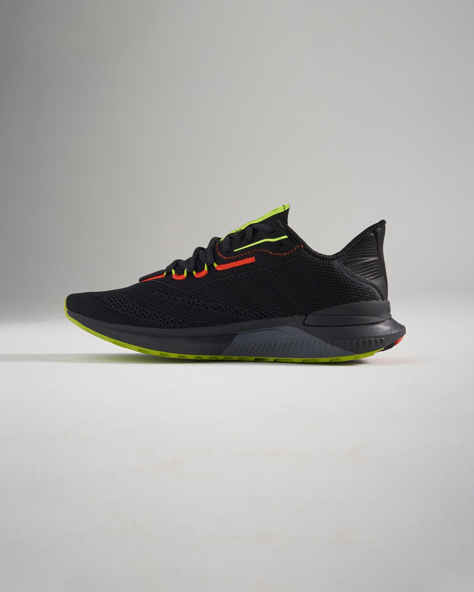 A sleek black running shoe featuring vibrant red and neon yellow accents designed for style and performance