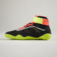 This image displays a stylish black athletic shoe featuring a high-top design accented with bright red laces and a vibrant green sole