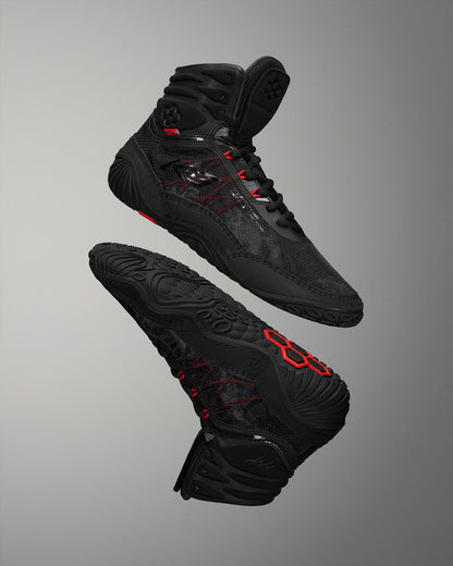 High-performance black wrestling shoes, designed for grip and support, showcase a breathable upper and textured sole against a soft gray background.