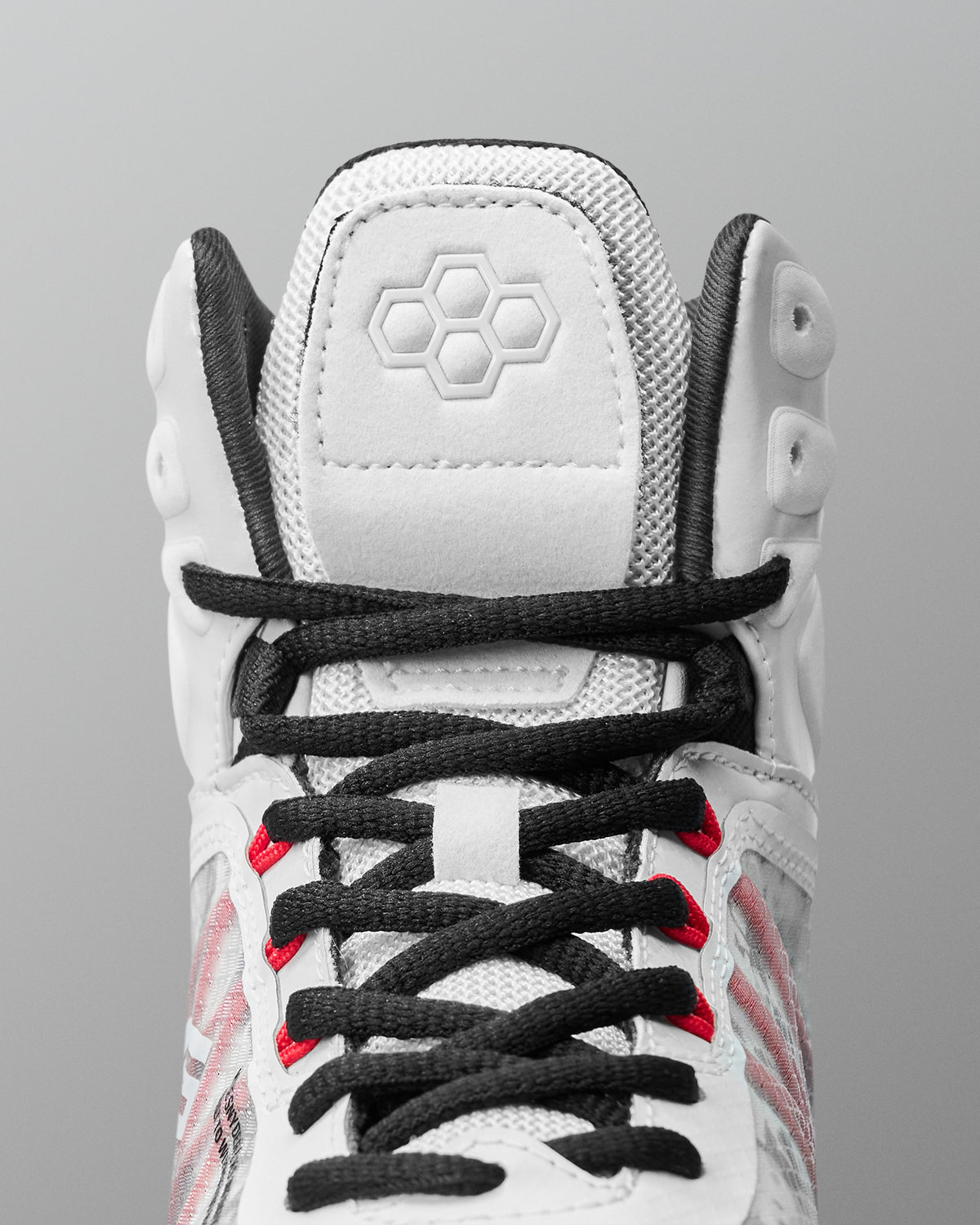 Close-up detail of RUDIS Infinity Edge wrestling shoe lacing system with black laces and red performance eyelets
