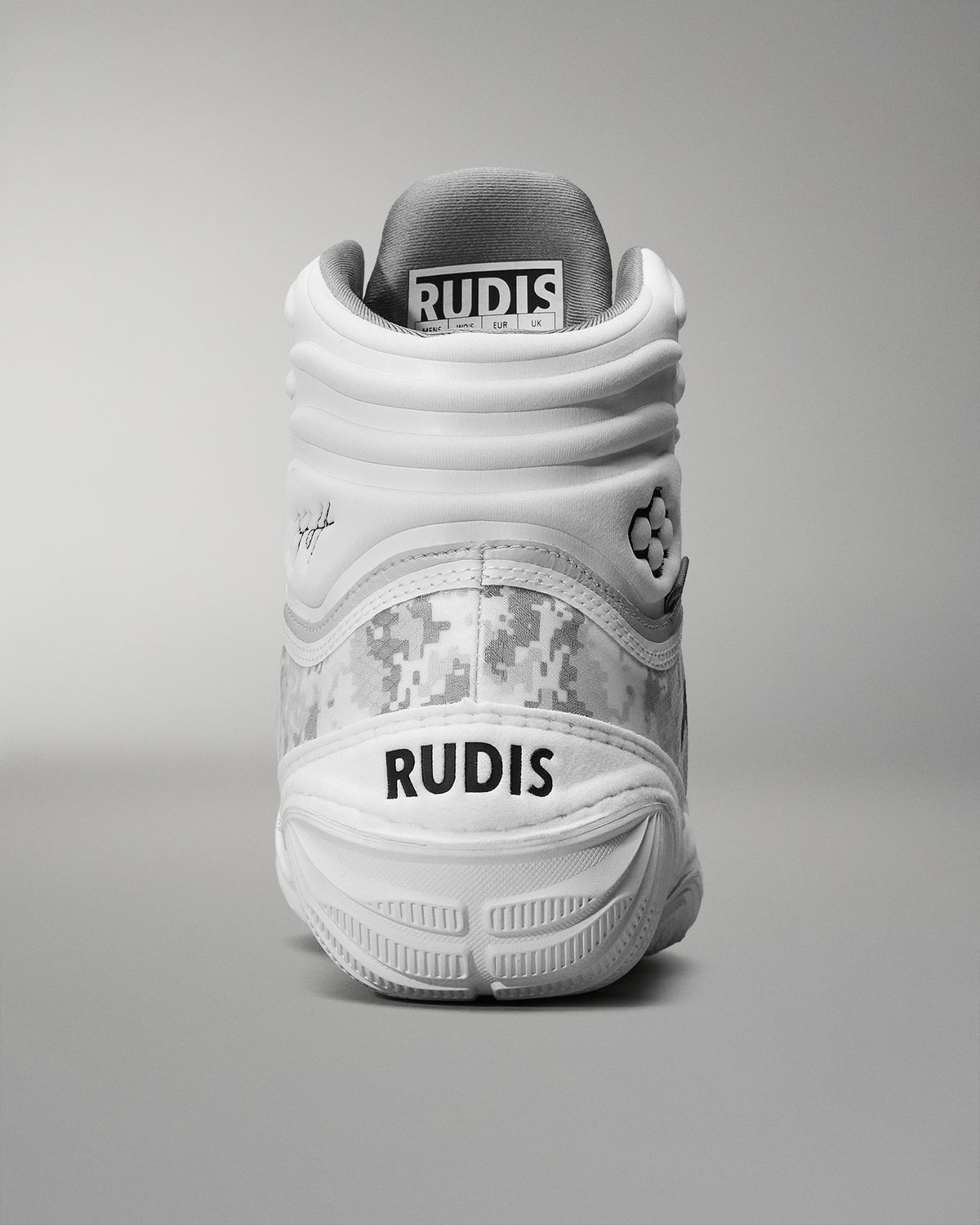 back view of white wrestling shoe with RUDIS word mark logo on heal