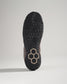 This image displays the detailed underside of a modern athletic shoe featuring a textured black rubber sole with unique patterns for enhanced grip and traction