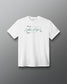 A white short-sleeve crewneck t-shirt featuring a green signature graphic and text on the chest, displayed against a dark gray gradient background.