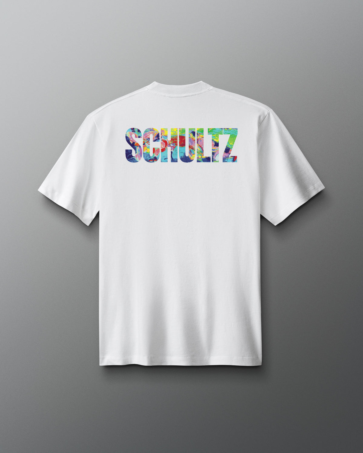 White t-shirt with colorful 'SCHULTZ' logo on the back against a gray background