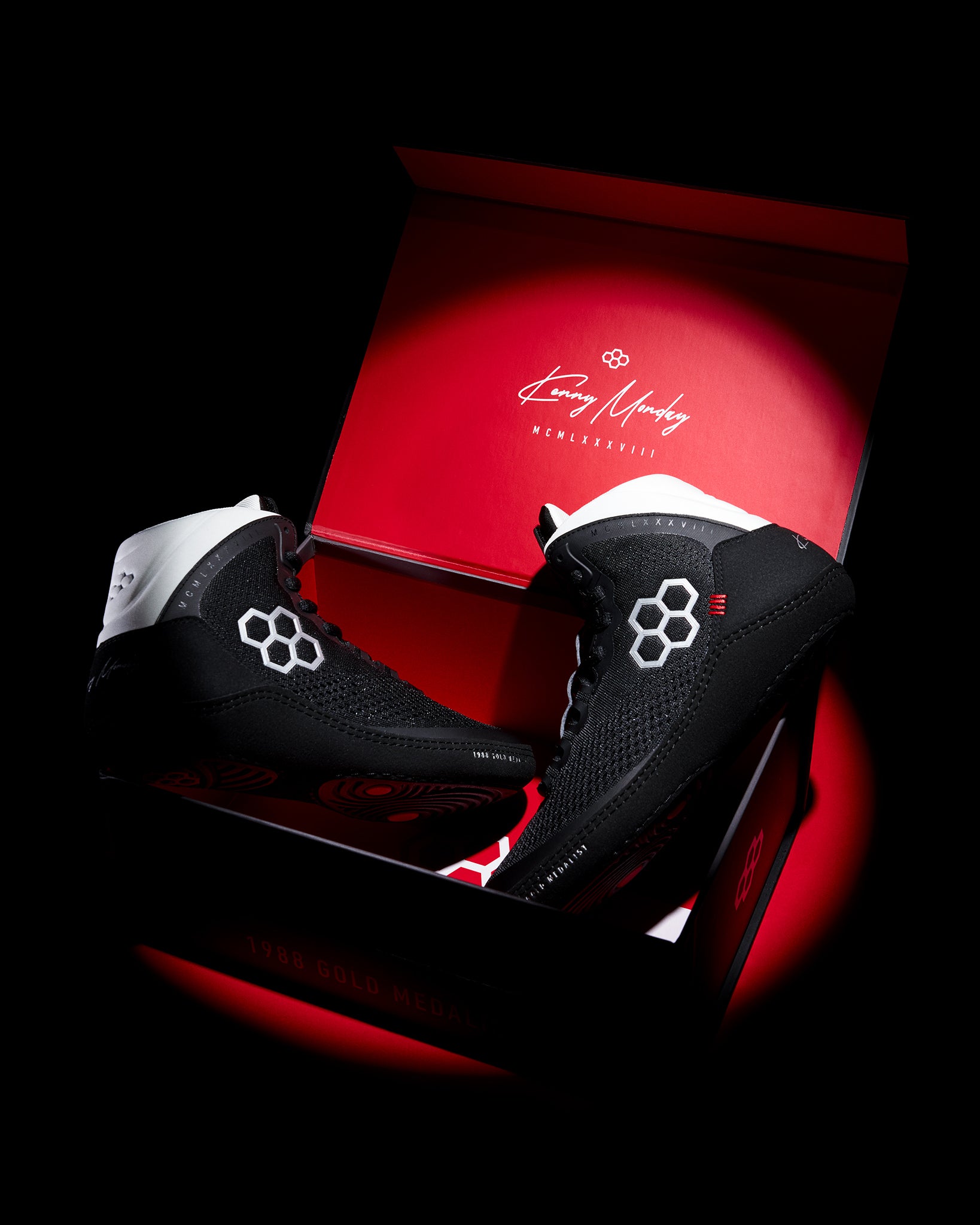 Black wrestling shoes with a unique design on a red box