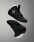 Black wrestling shoes with white soles on a gray background