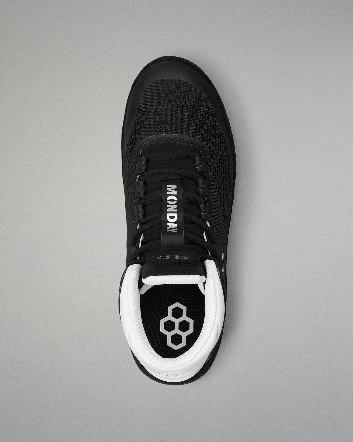 Black wrestling shoe with white sole on a gray background