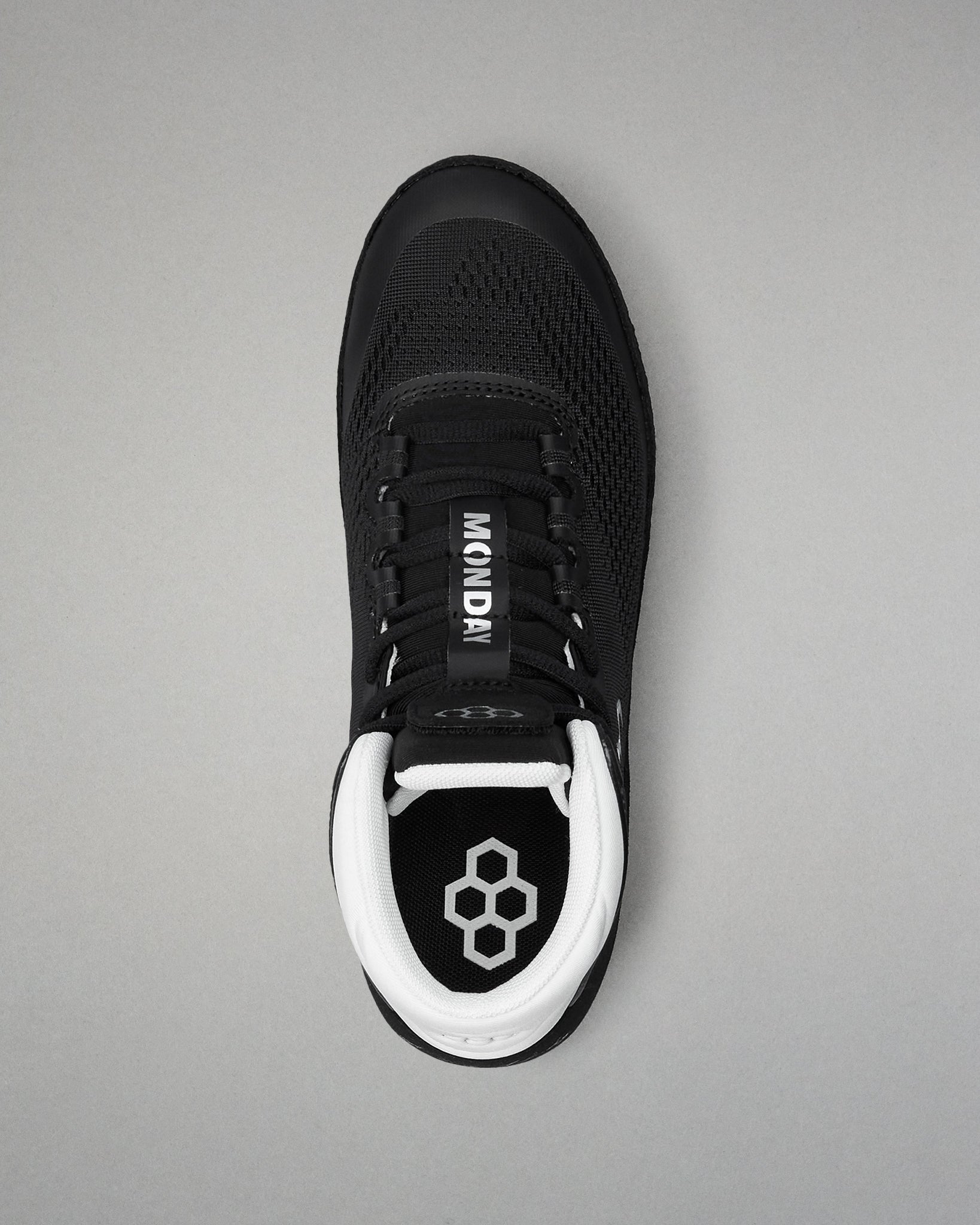 Black wrestling shoe with white sole on a gray background