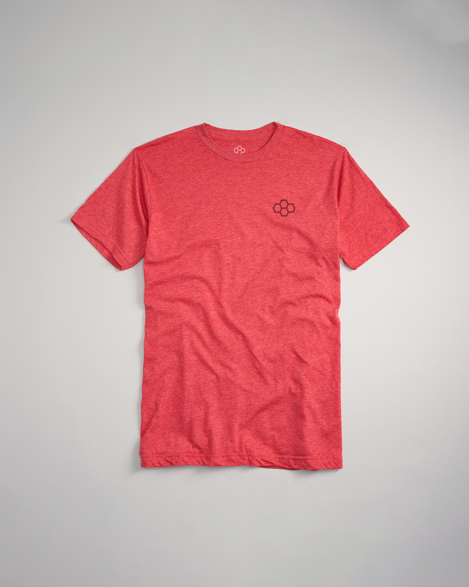 A vibrant red t-shirt featuring a subtle black logo on the chest laid flat against a light gray background