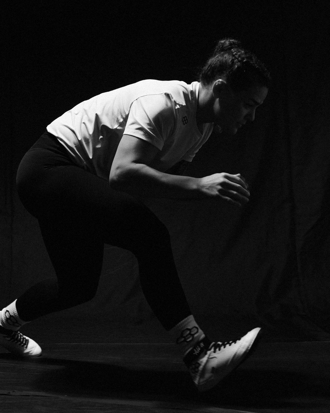 Athlete Kayla Miracle in a wrestling stance wearing RUDIS performance apparel and wrestling shoes, showcasing speed, agility, and mat-ready movement.