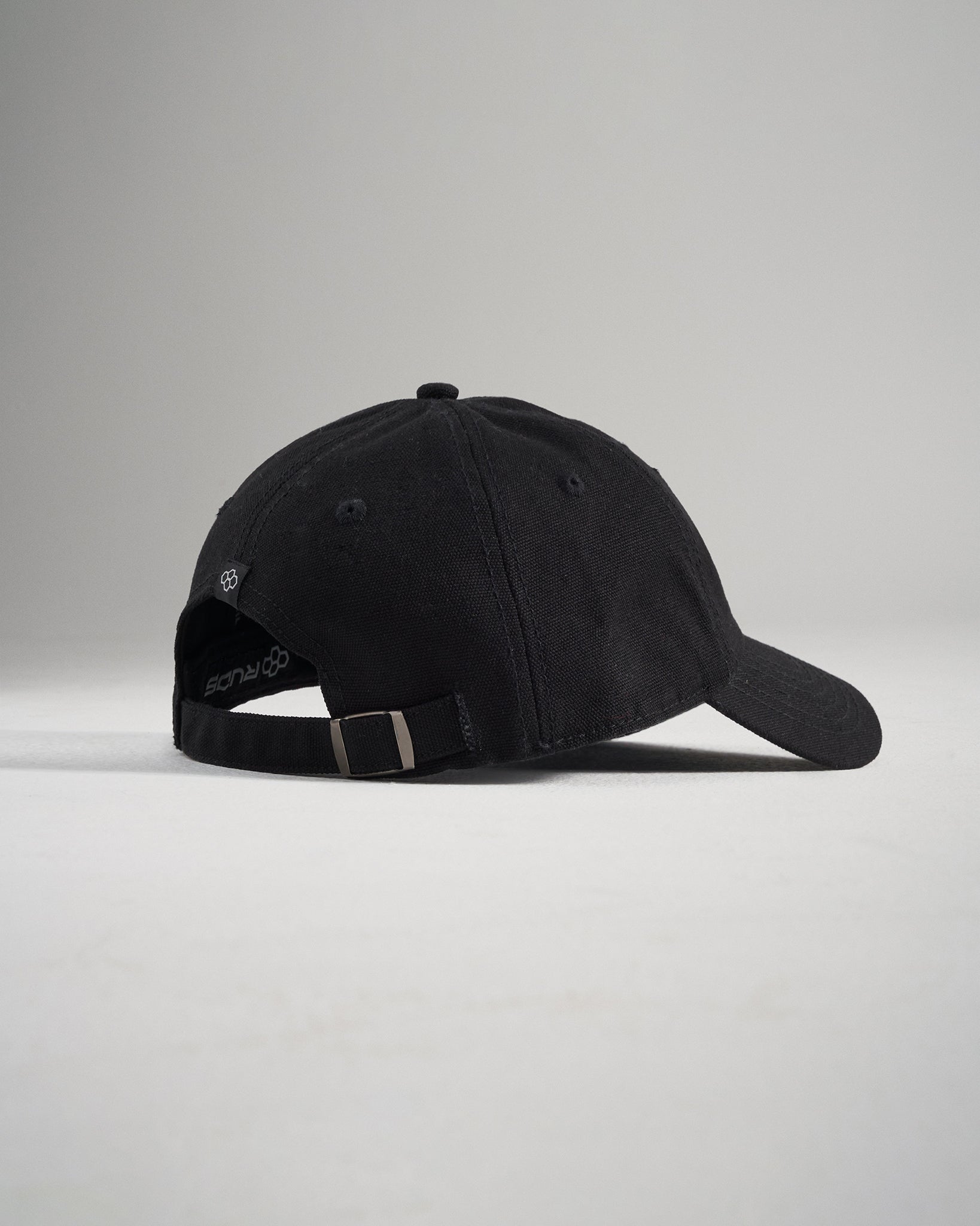 A stylish black baseball cap featuring a soft fabric finish and an adjustable strap at the back for a comfortable fit