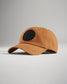 A stylish brown cap featuring a black circular logo with the text RUDIS APPAREL