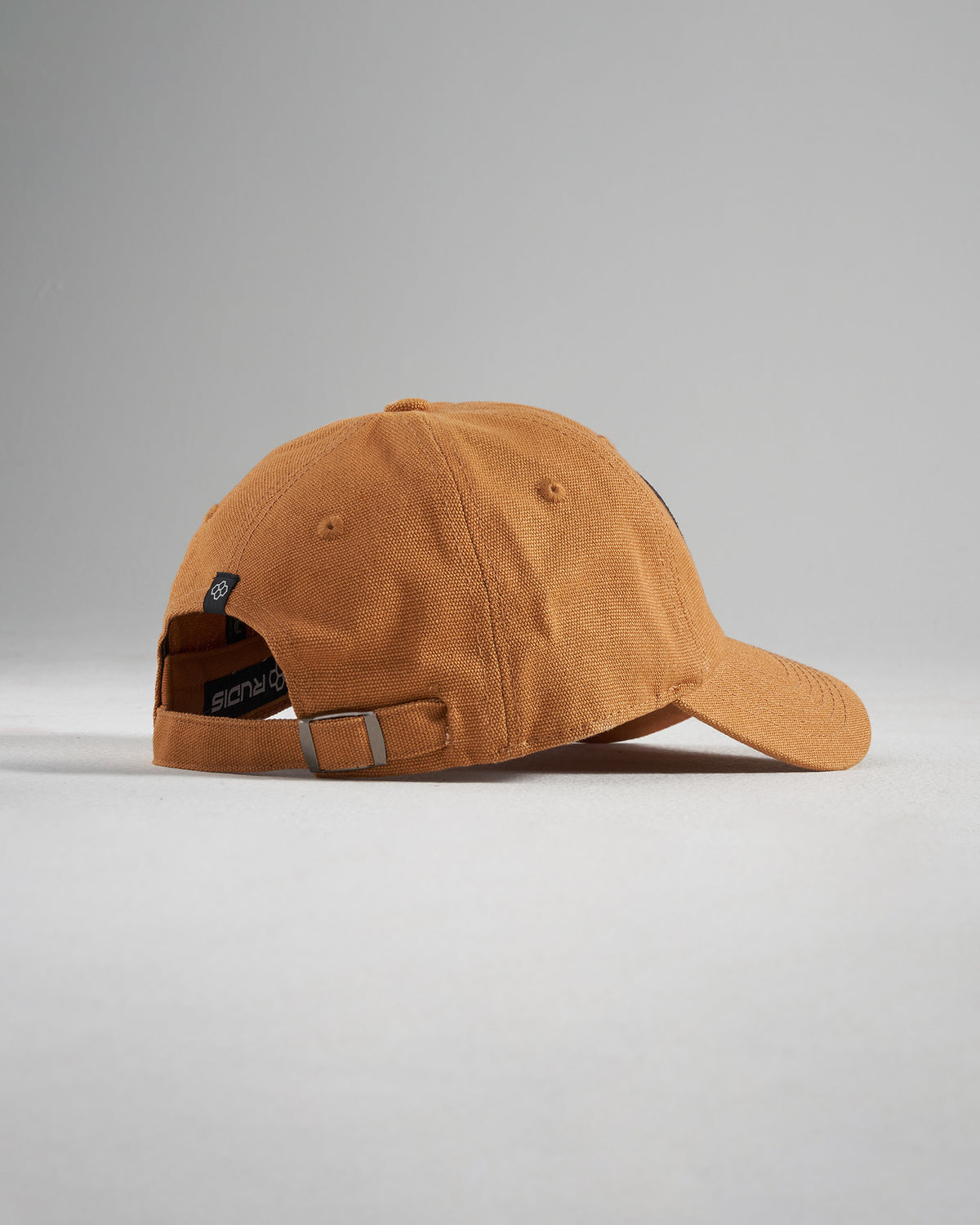 A stylish rust-colored baseball cap with a simple design featuring a rounded shape and an adjustable strap at the back