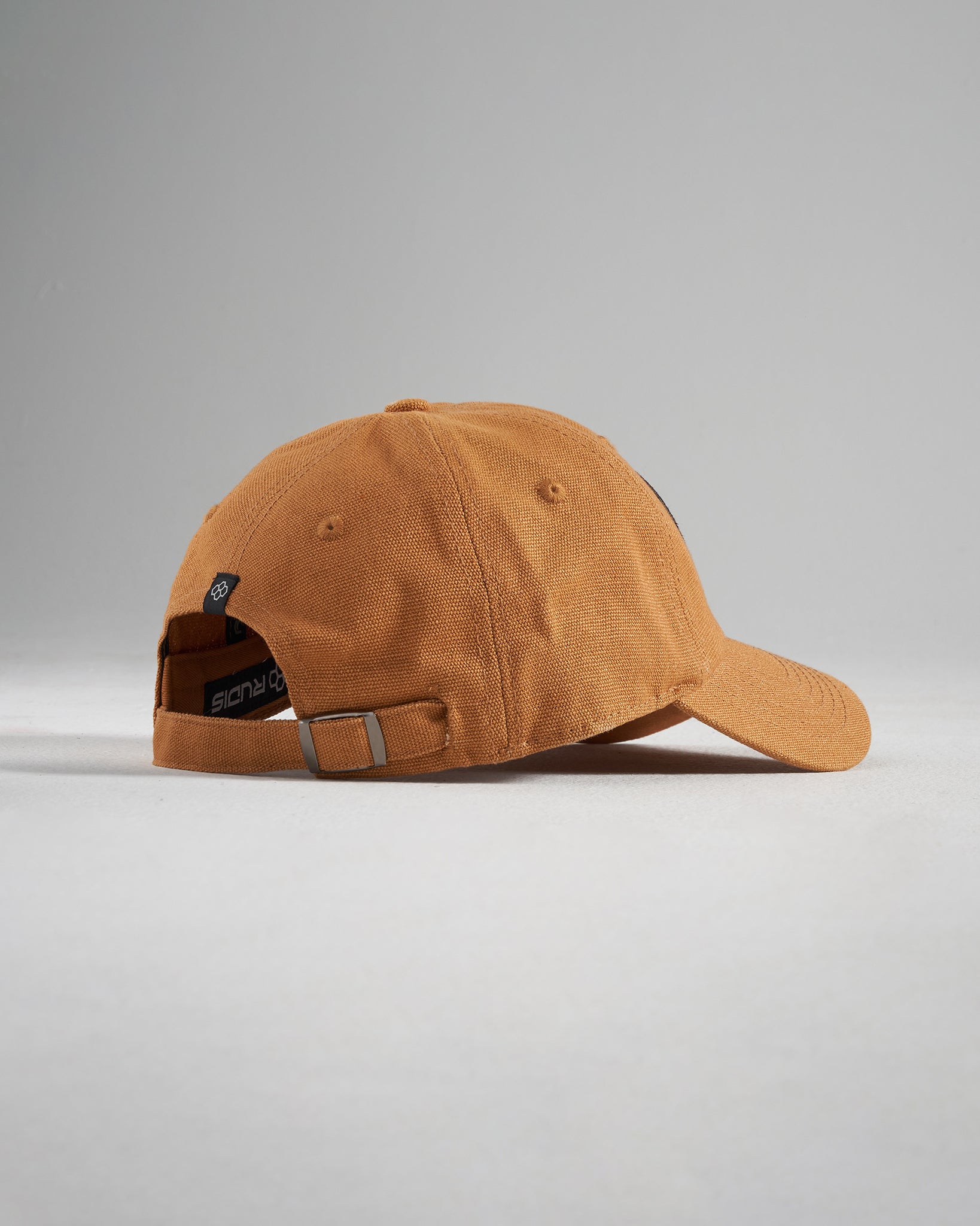 A stylish rust-colored baseball cap with a simple design featuring a rounded shape and an adjustable strap at the back