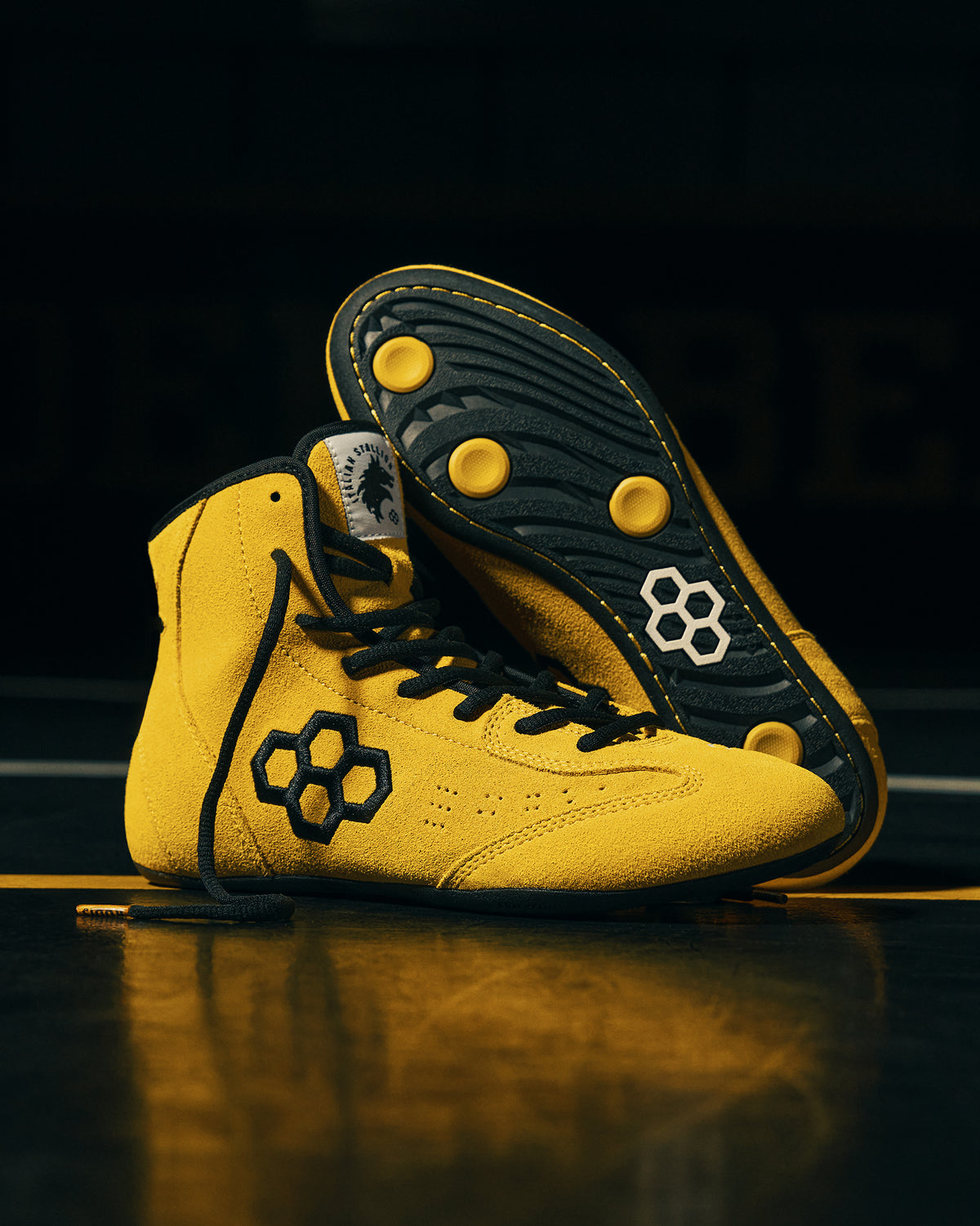 Yellow RUDIS Rocky International Wrestling Shoes staged together with one shoe displaying the black traction outsole. Italian stallion logo on the tongue