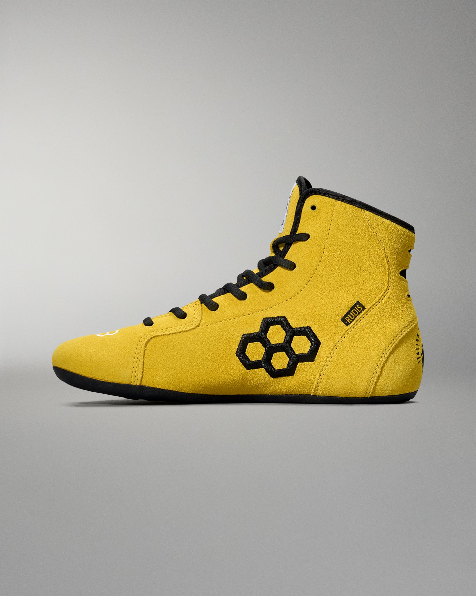 Side profile of the yellow RUDIS Rocky International Adult Wrestling Shoe with black RUDIS logo and laces.