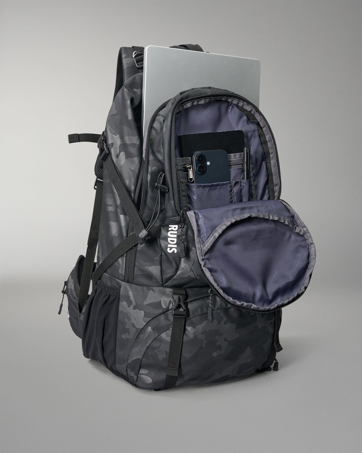 Camouflage backpack with open front pocket on a gray background