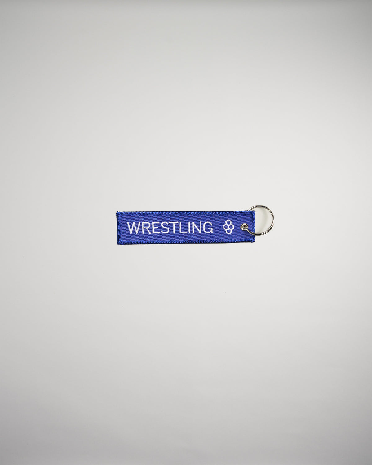 A vibrant blue keychain tag labeled WRESTLING featuring a decorative emblem on one end