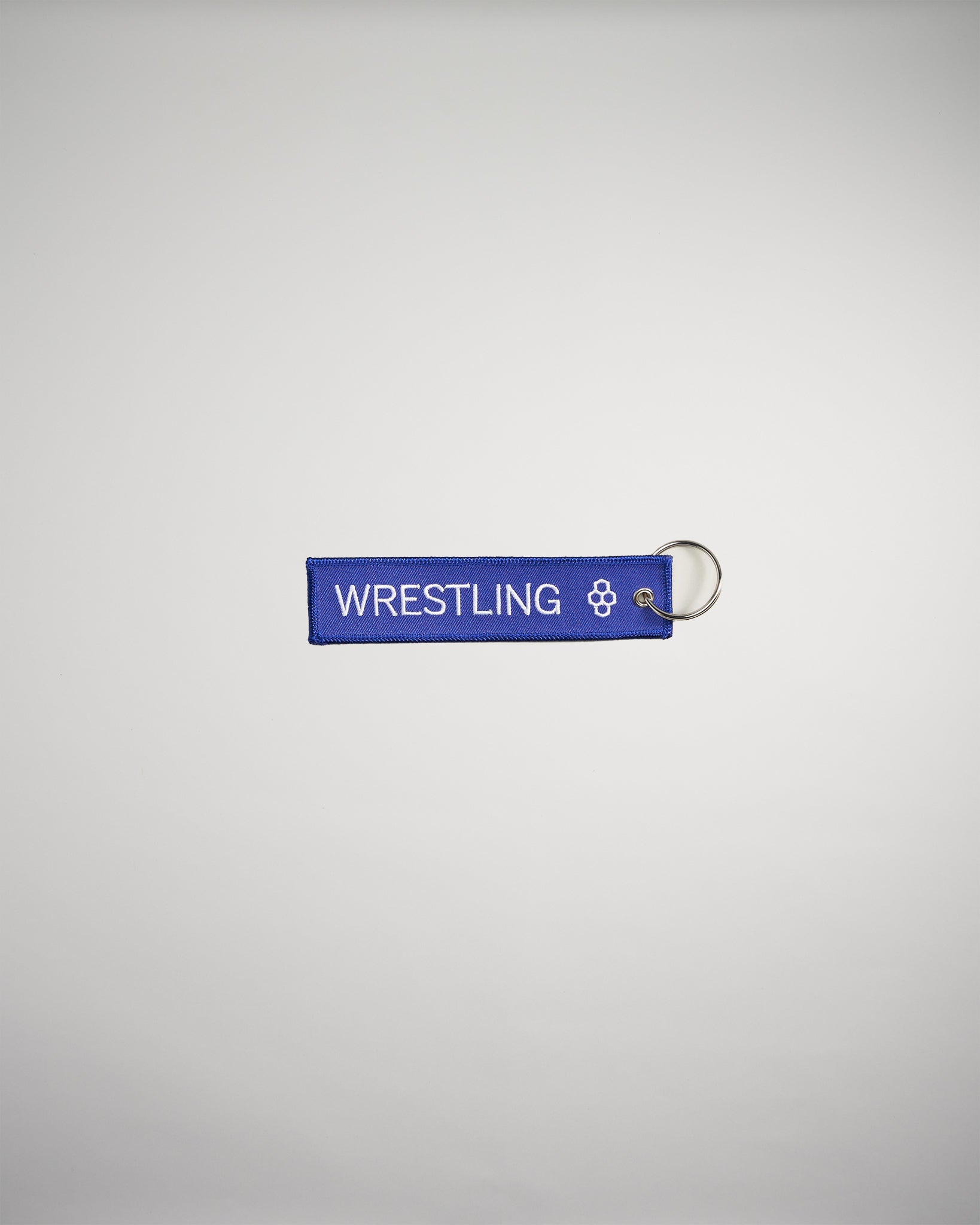 A vibrant blue keychain tag labeled WRESTLING featuring a decorative emblem on one end