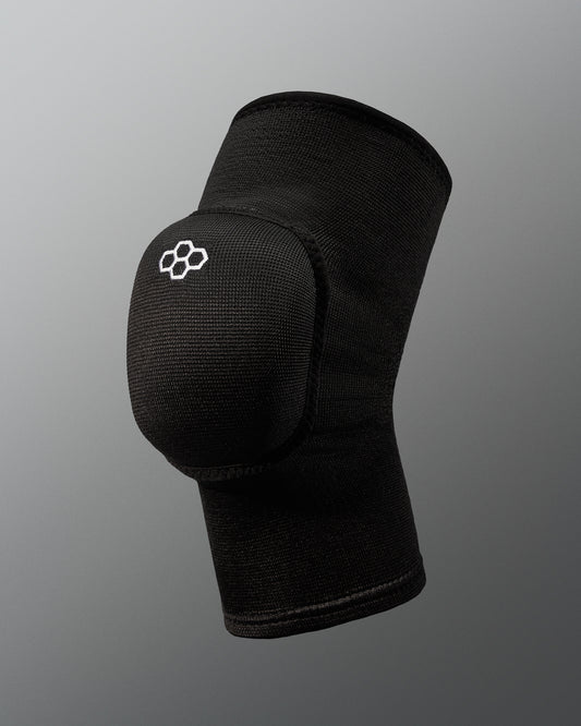 A black wrestling knee pad with a rounded protective cap and logo offers support for athletes, featuring breathable fabric and a minimalist design against a soft gray background.