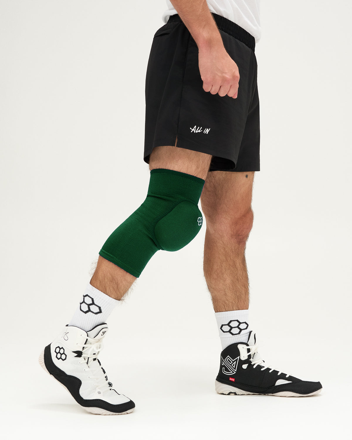 Person wearing green knee pads on a white background