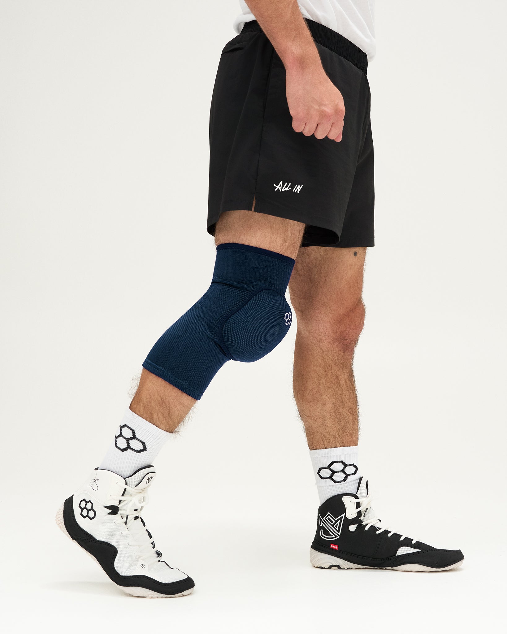 Person wearing navy knee sleeves on a white background