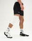 Person wearing a white knee pad and white sneakers with a quadhex design on a white background