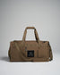 A sturdy tan duffel bag featuring a textured fabric a prominent black logo and multiple pockets for organization
