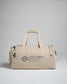 A beige utility duffel bag featuring multiple zippered compartments and a modern design highlighted by an embossed logo and tagline emphasizing its athletic purpose