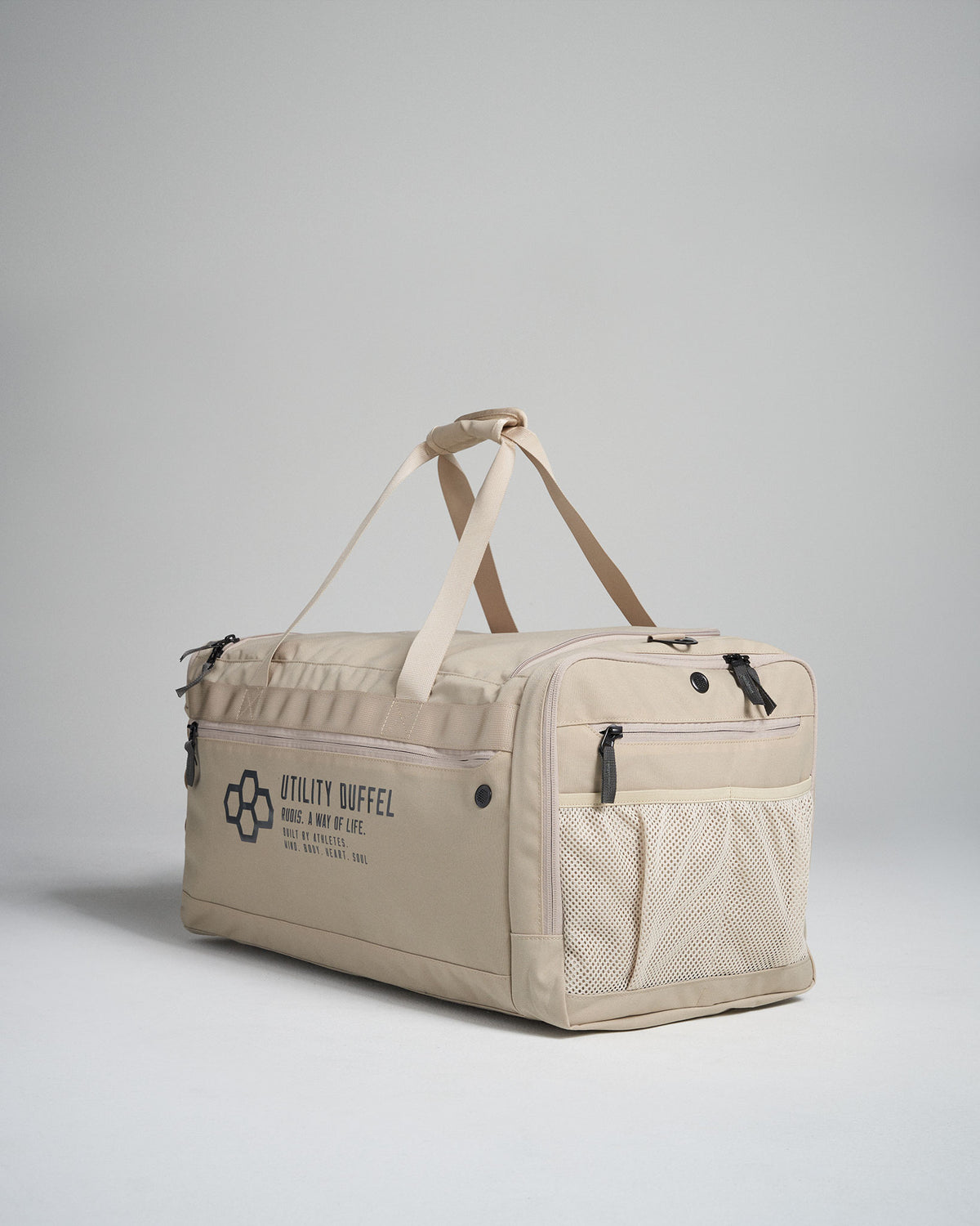 A modern beige utility duffel bag featuring multiple compartments sturdy handles and a mesh pocket ideal for travel or gym use