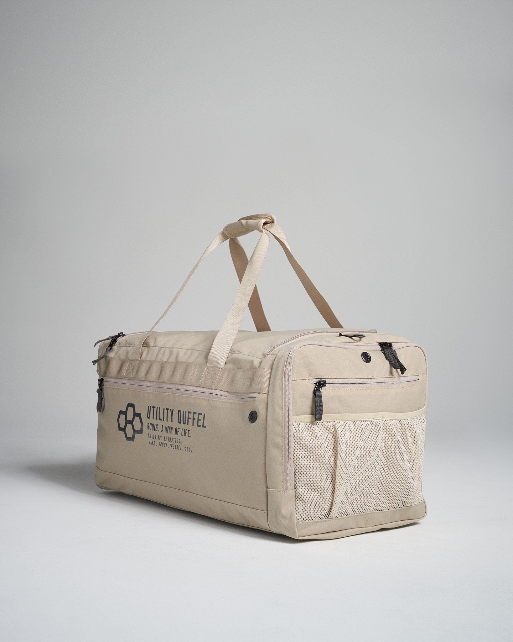 A modern beige utility duffel bag featuring multiple compartments sturdy handles and a mesh pocket ideal for travel or gym use