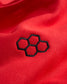 A close-up view of a red fabric featuring a black hexagonal embroidered logo