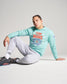 A young man in a light blue sweatshirt with TEAM RUDIS printed on it paired with gray sweatpants and athletic shoes poses confidently on the floor
