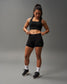 Woman wearing black athletic wear on a gray background