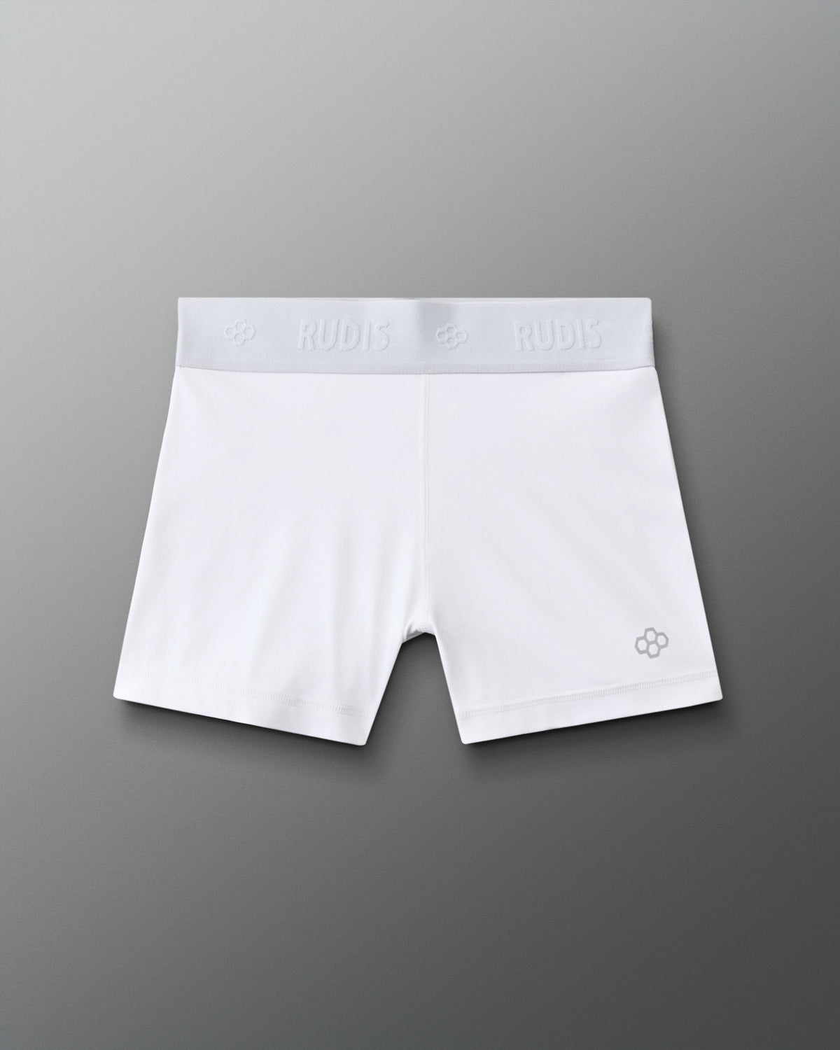 Front view of the RUDIS Women's Compression Shorts in White, featuring a wide RUDIS-branded elastic waistband, fitted silhouette and signature gray RUDIS emblem on the leg.