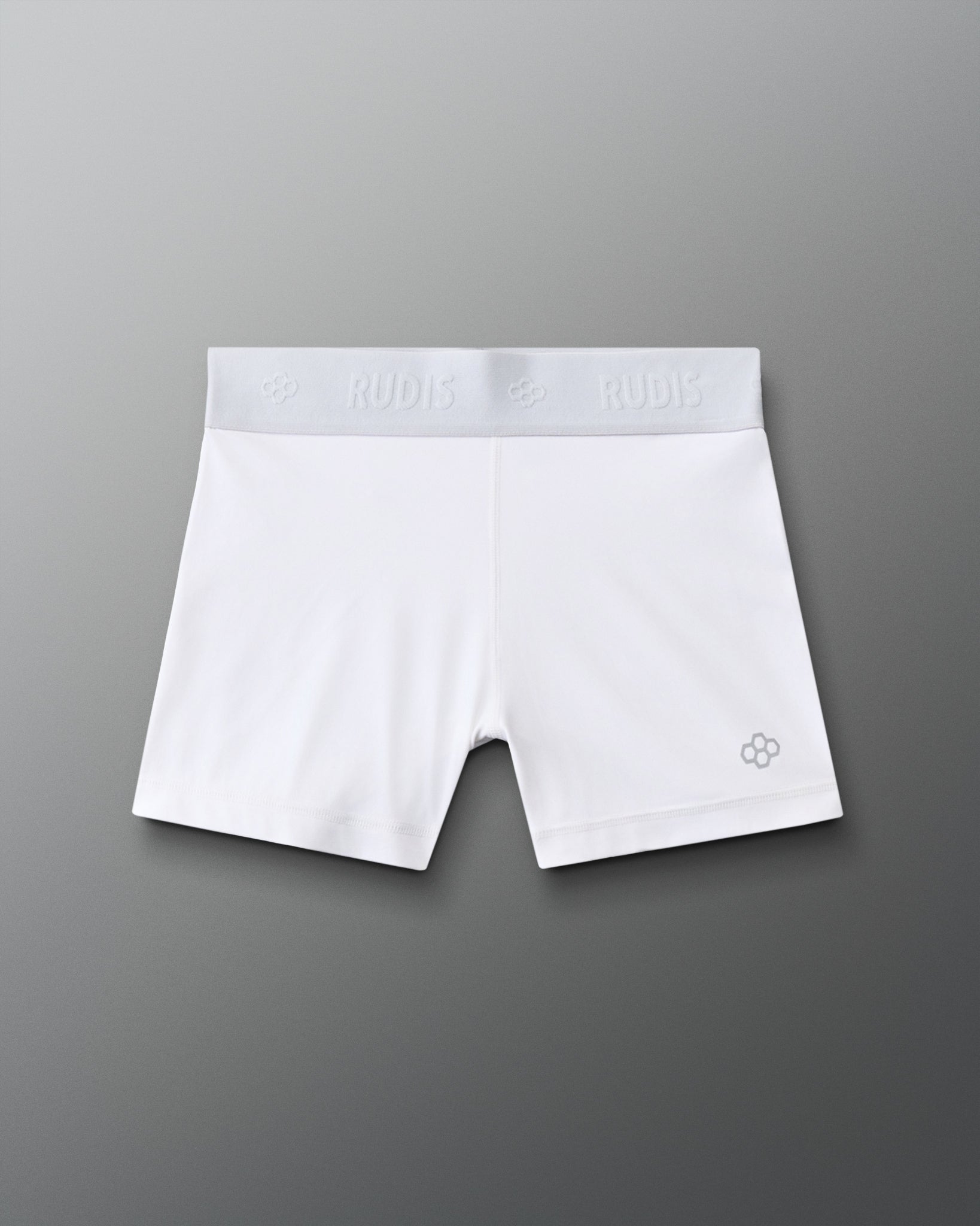 Front view of the RUDIS Women's Compression Shorts in White, featuring a wide RUDIS-branded elastic waistband, fitted silhouette and signature gray RUDIS emblem on the leg.