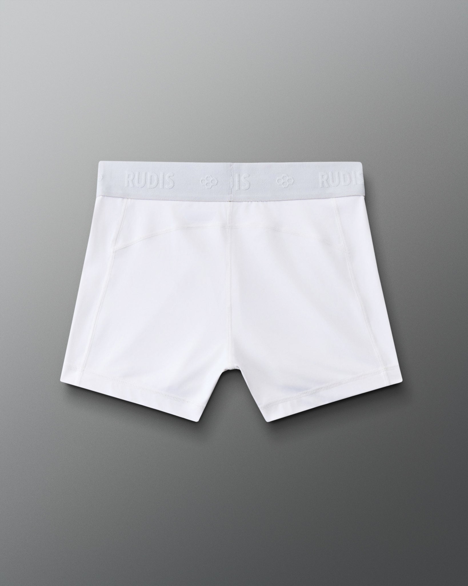 Back view of the RUDIS Women's Compression Shorts in White, showcasing the RUDIS-branded elastic waistband, contoured seam construction and fitted athletic design.