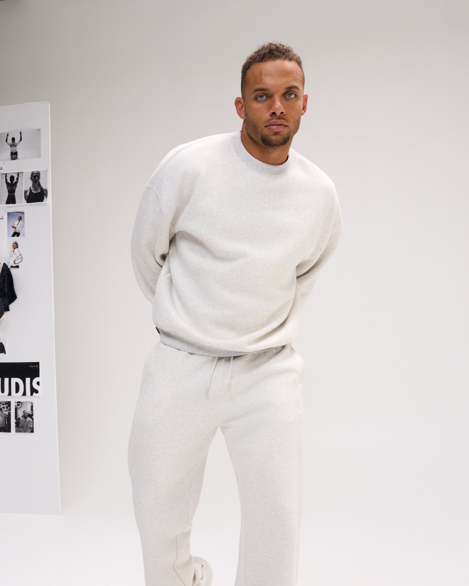 Man modeling the RUDIS Hex Relaxed Comfort Fleece Crewneck in Heather Silver, paired with matching fleece pants for a coordinated casual look.
 Copy alt text