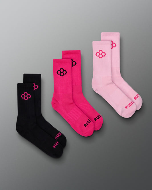Three pairs of socks in black, pink, and light pink on a gray background