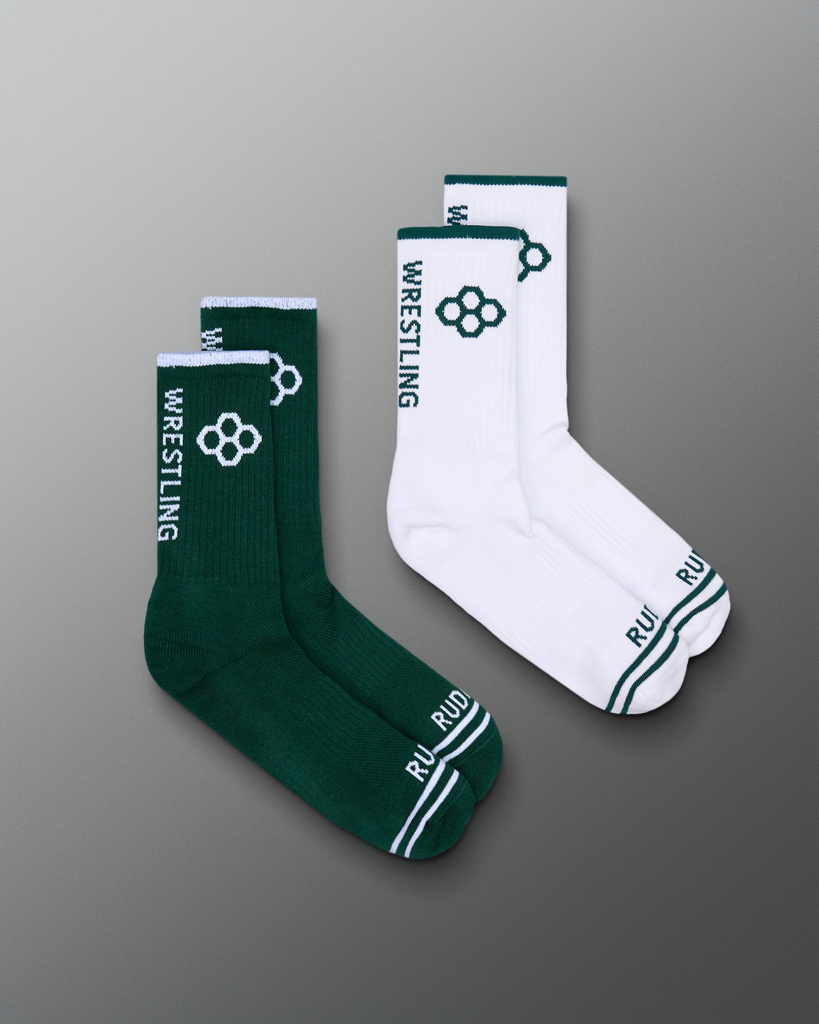 Green and white wrestling socks on a gray background