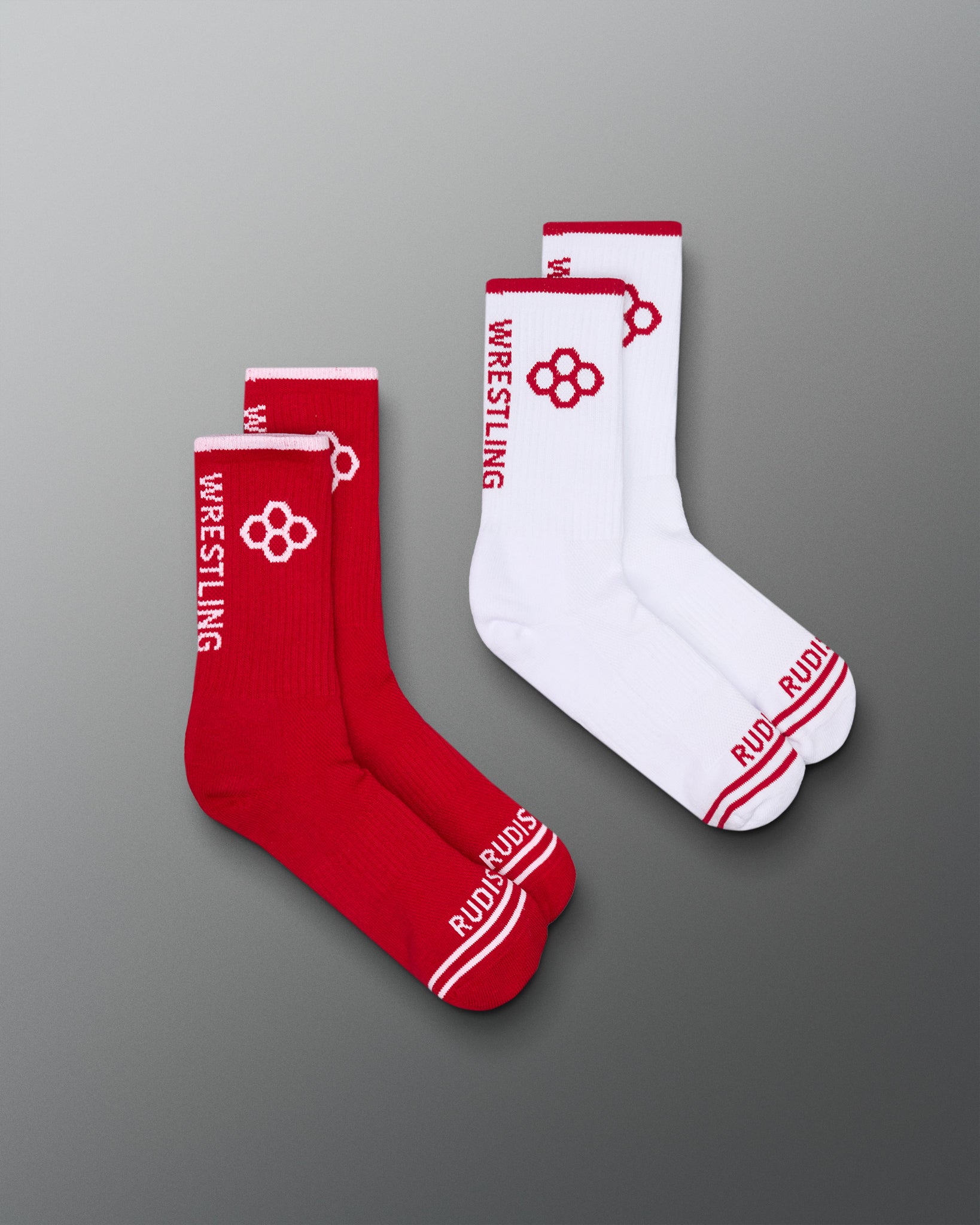 Red and white wrestling socks with visible branding on a gray background