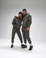 Two people wearing matching gray hoodies and pants on a white background