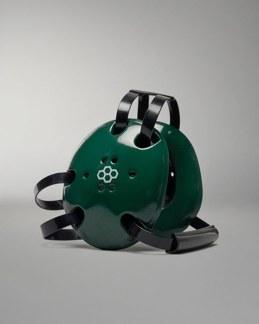 Green helmet with black straps on a gray background