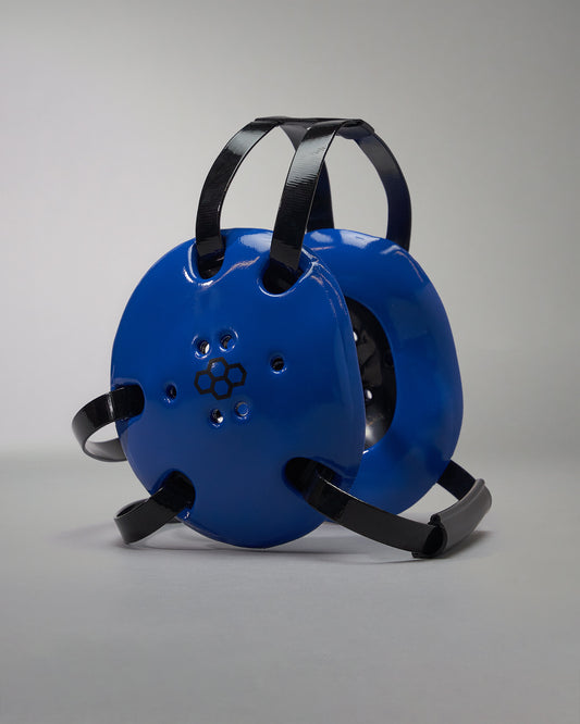 Blue wrestling headgear with black straps on a gray background