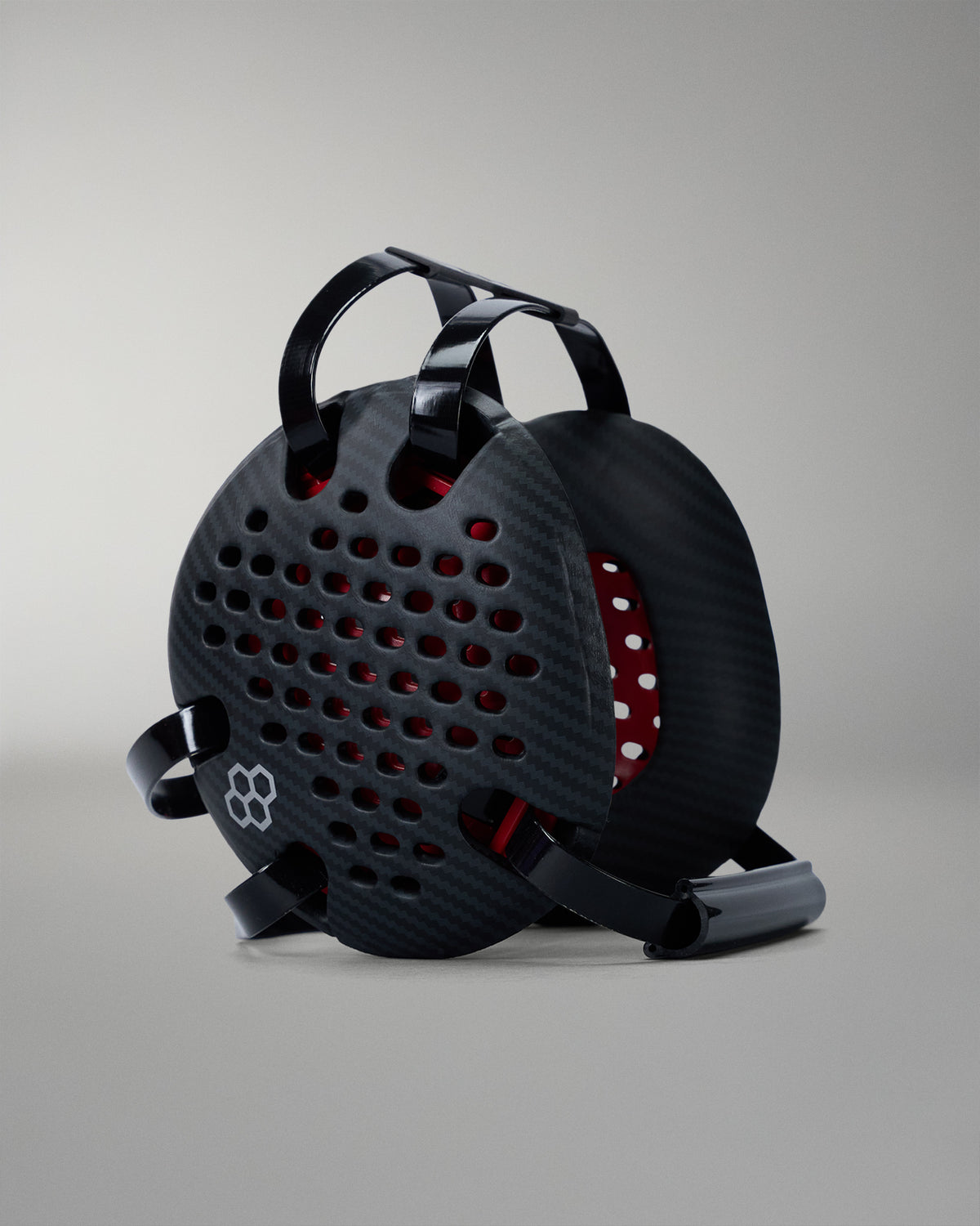 Black wrestling headgear with red interior on a gray background