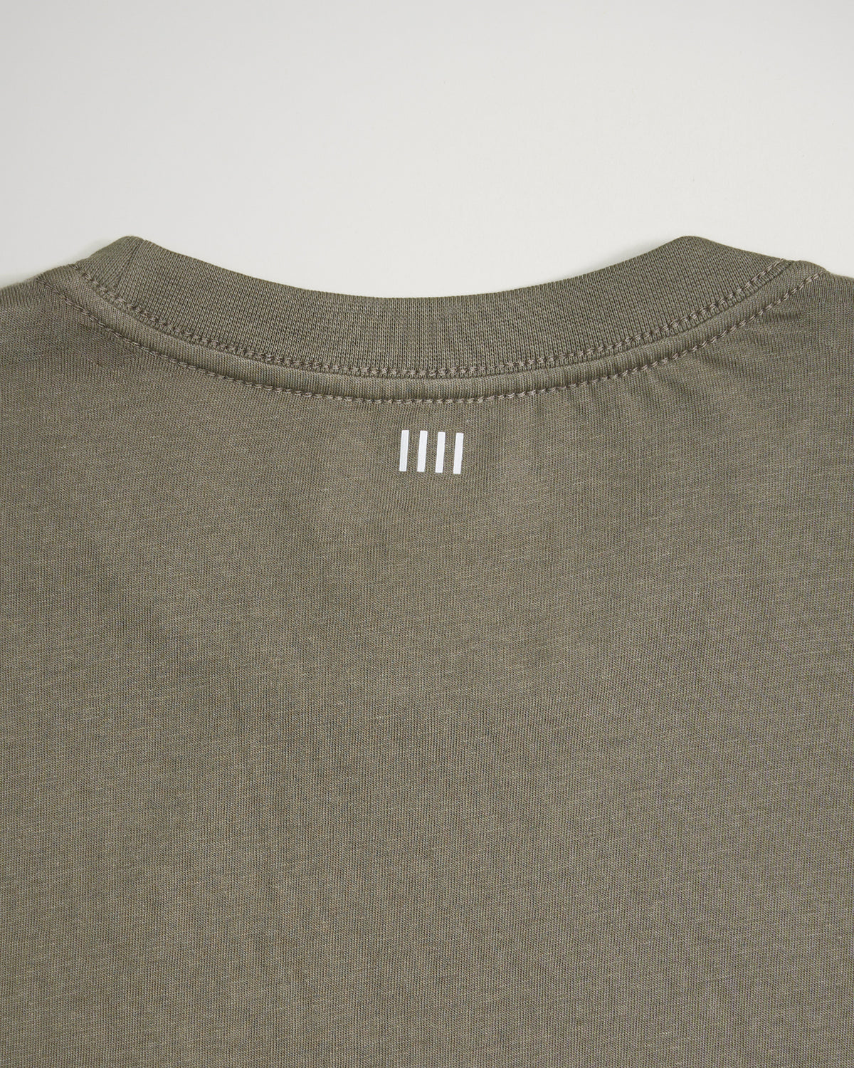 The back of a casual olive green t-shirt featuring a simple white logo printed near the neckline