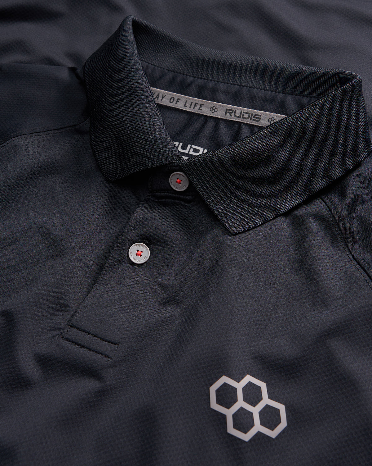 A close-up view of a black polo shirt featuring a classic collar two buttons and a geometric logo in a contrasting shade