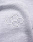 A close-up view of a light gray fabric featuring an embroidered honeycomb design showcasing soft texture and fine detailing