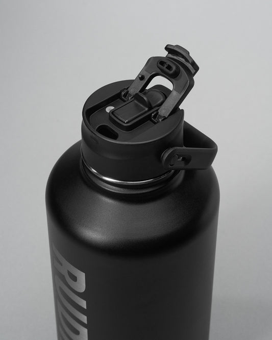 Black water bottle with a screw-on cap on a light gray background
