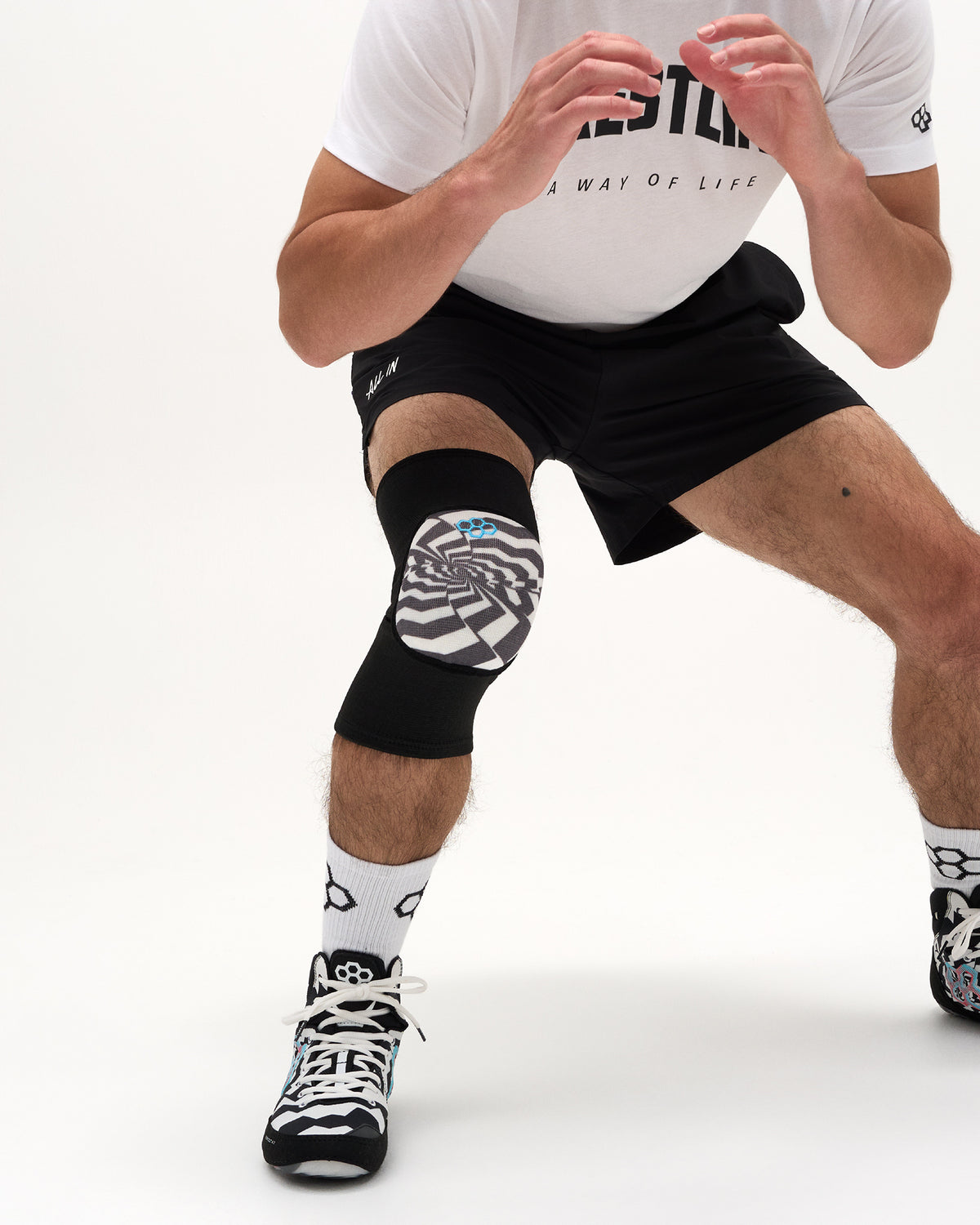 RUDIS Cushion Hypnosis Wrestling Knee Pad worn by a wrestler in an athletic stance